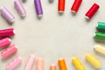 Frame made of colorful thread spools on light backgroundの写真素材