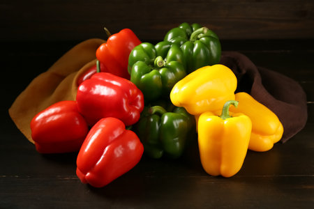 Heap of fresh colorful bell peppers on wooden backgroundの写真素材