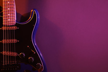 Modern electric guitar on purple backgroundの写真素材