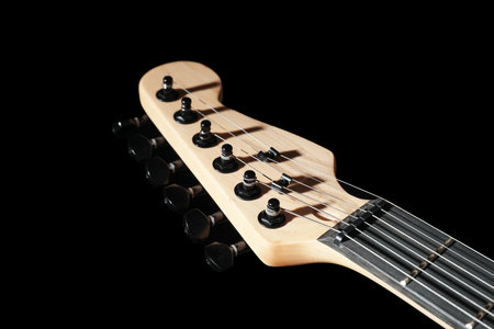 Modern electric guitar on black background, closeup