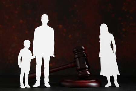 Judge's gavel with figures of family on black table near grunge wallの写真素材