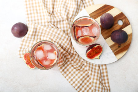 Glasses of tasty fig lemonade and fruits on white backgroundの写真素材