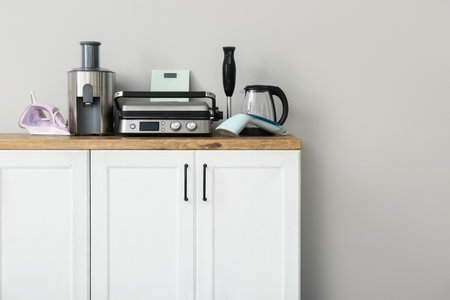 Different household appliances on counter against white wallの写真素材