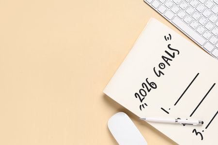 Notebook with 2026 goals and computer keyboard on beige backgroundの写真素材