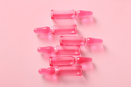 Glass ampoules on pink backgroundの写真素材