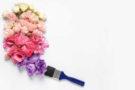 Floral composition with fresh flowers and paint brush on white backgroundの写真素材