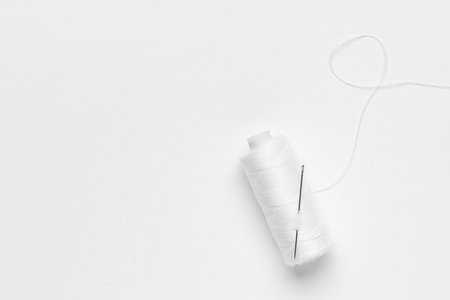 Spool of thread with needle on white backgroundの写真素材