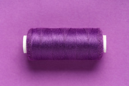 Spool of thread on purple background