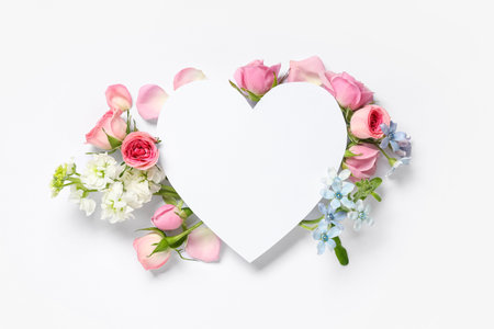 Blank card in shape of heart with different beautiful flowers on white background