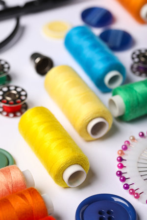 Composition with different thread spools and accessories on white background, closeupの写真素材