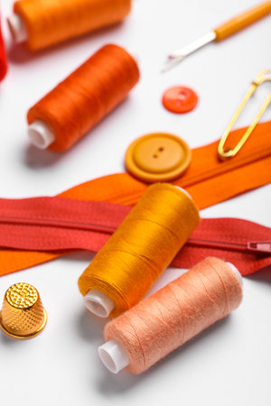 Composition with thread spools, zippers and thimble on white background, closeupの写真素材