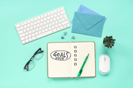 Notebook with 2026 goals, computer keyboard and envelopes on green backgroundの写真素材