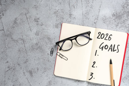 Notebook with 2026 goals and eyeglasses on grunge backgroundの写真素材