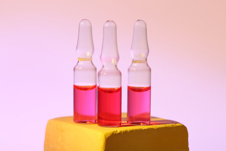 Glass ampoules on color backgroundの写真素材