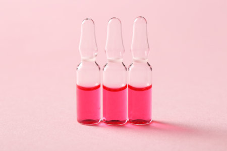 Glass ampoules on pink backgroundの写真素材