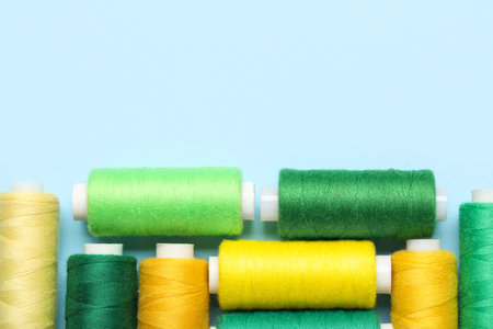 Different sewing thread spool on blue background, closeupの写真素材