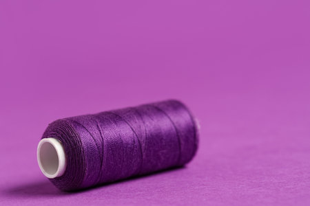Spool of thread on purple backgroundの写真素材