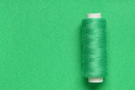 Spool of thread on green background