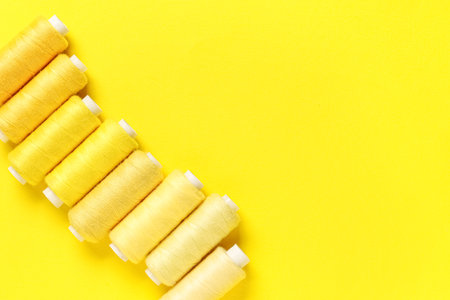 Spools of thread on yellow backgroundの写真素材