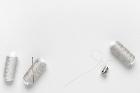 Spools of thread with needle on gray backgroundの写真素材