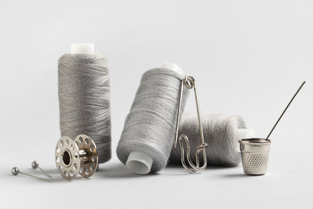 Spools of thread and sewing supplies on gray backgroundの写真素材
