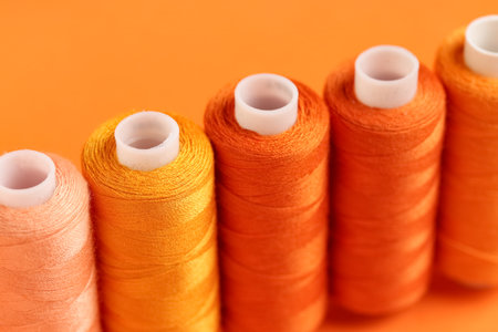 Spools of thread on orange background, closeupの写真素材