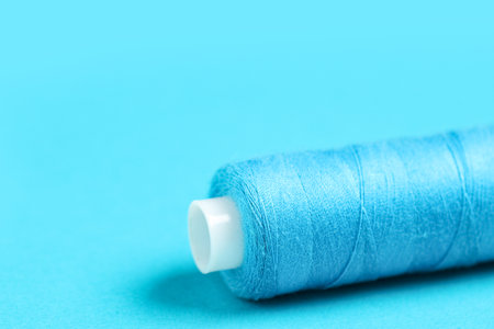 Spool of thread on blue background, closeupの写真素材