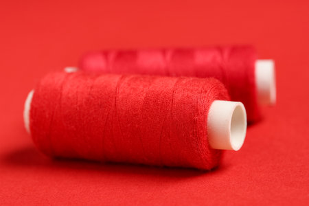 Spools of thread on red background, closeupの写真素材