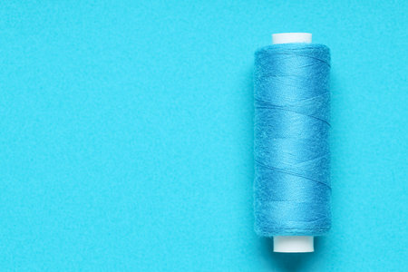Spool of thread on blue background
