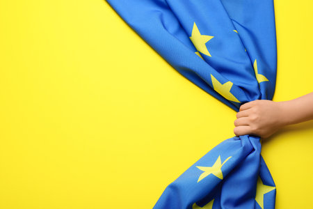 Hand and flag of European Union on yellow backgroundの写真素材