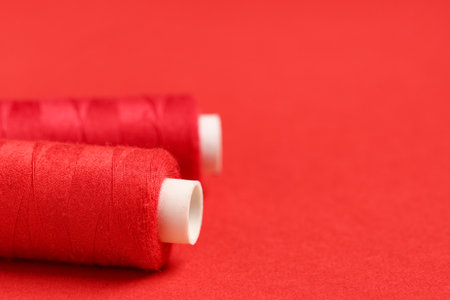 Spools of thread on red background, closeupの写真素材
