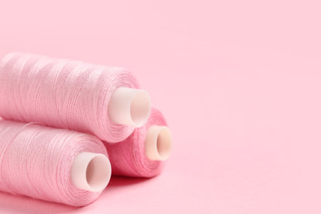 Spools of thread on pink background, closeupの写真素材
