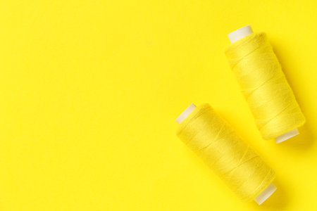 Spools of thread on yellow background