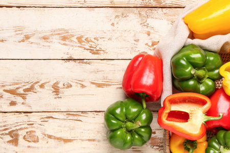 Wicker tray with fresh colorful bell peppers on white wooden backgroundの写真素材