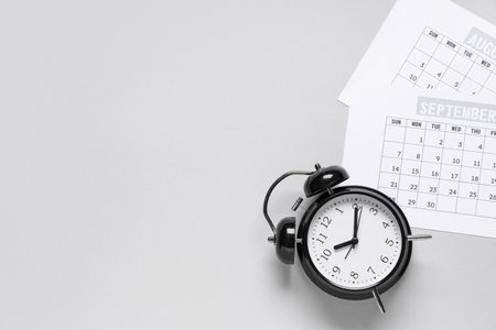 Calendar with alarm clock on gray backgroundの写真素材