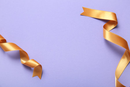 Golden satin ribbons on purple backgroundの写真素材