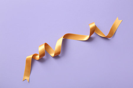 Golden ribbon on purple backgroundの写真素材