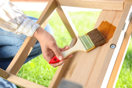 Woman painting wooden step stool in garden, closeupの写真素材