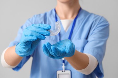 Female dentist with occlusal splint on gray background, closeupの写真素材