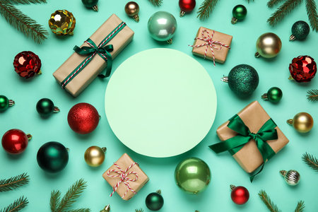 Blank card with Christmas balls, gift boxes and fir branches on turquoise backgroundの写真素材
