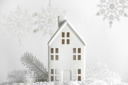 Christmas toy house with fir branches and snowflakes on white backgroundの写真素材