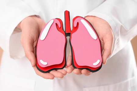 Female doctor with paper lungs on beige background, closeupの写真素材