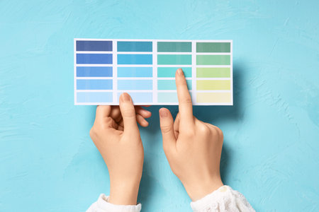 Woman pointing at color palette on grunge blue background