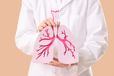 Female doctor with paper lungs on beige background, closeupの写真素材