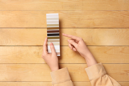 Woman pointing at color palette on brown wooden backgroundの写真素材