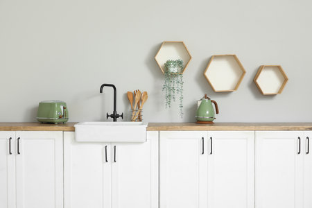 Interior of stylish kitchen with white counters, appliances and sinkの写真素材