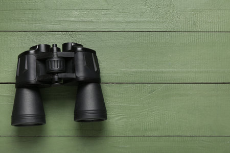 Modern binoculars on green wooden backgroundの写真素材