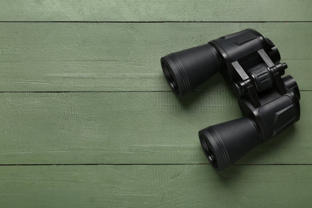 Modern binoculars on green wooden backgroundの写真素材