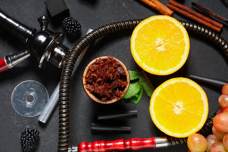 Parts of hookah with tobacco, berries, fruits and mint leaves on black background