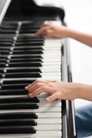 Cute little girl playing grand piano at home, closeupの写真素材